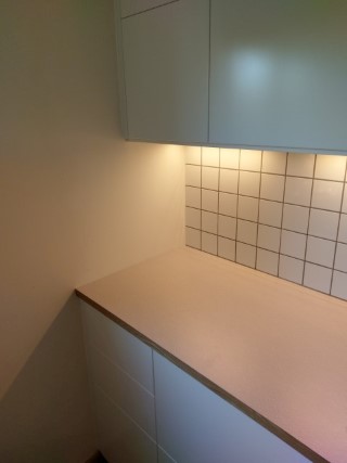 vägganslutning av vitt kök med virrvarr